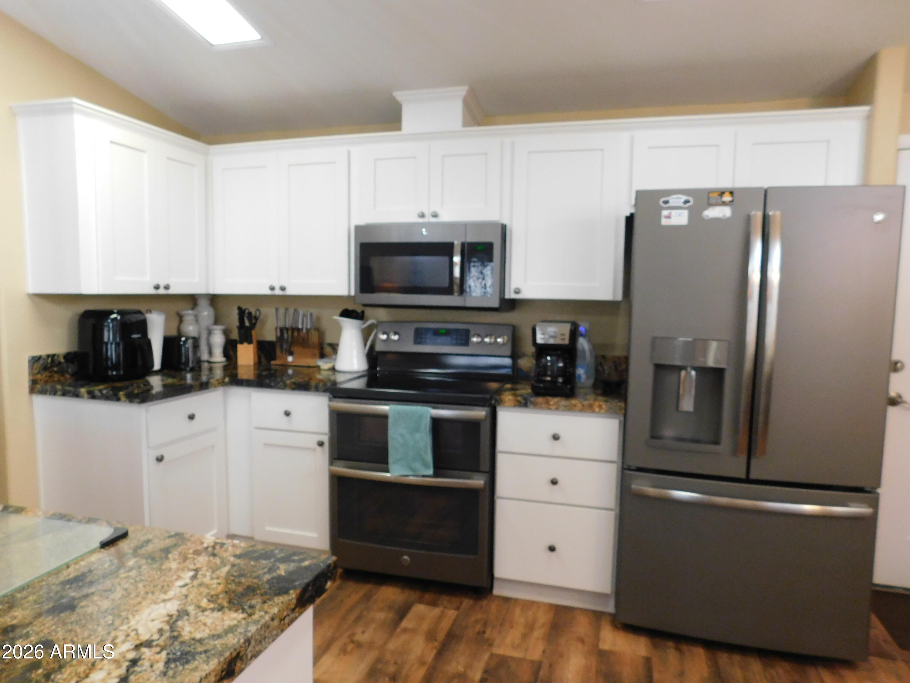 3301 South Goldfield Road, Unit 1054 Apache Junction, AZ 85119 - Photo 15 of 41 a kitchen with stainless steel appliances a refrigerator stove and microwave