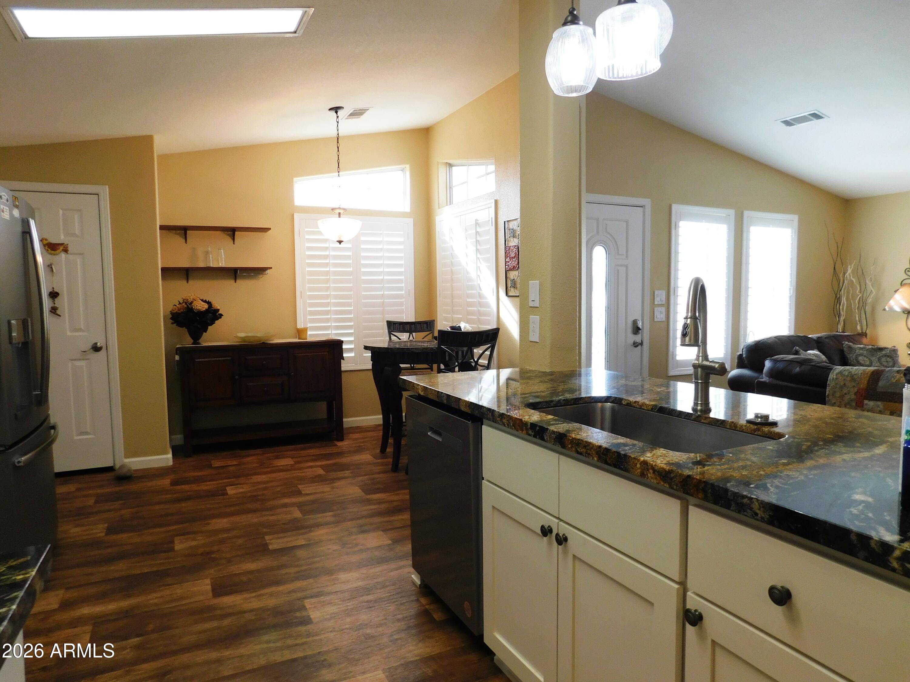 3301 South Goldfield Road, Unit 1054 Apache Junction, AZ 85119 - Photo 20 of 41 a kitchen with granite countertop a sink cabinets and wooden floor