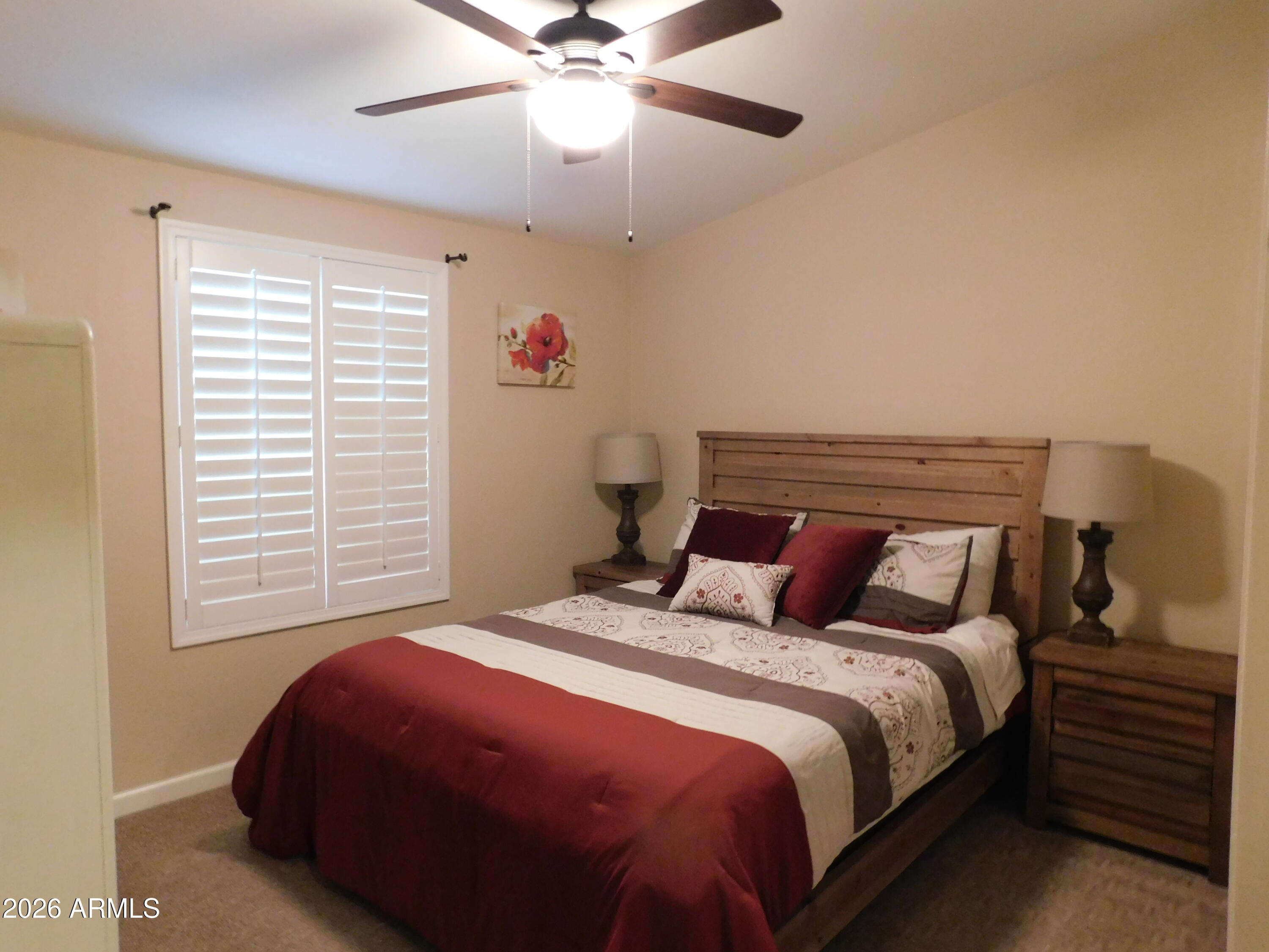 3301 South Goldfield Road, Unit 1054 Apache Junction, AZ 85119 - Photo 23 of 41 a bedroom with a bed and a chandelier