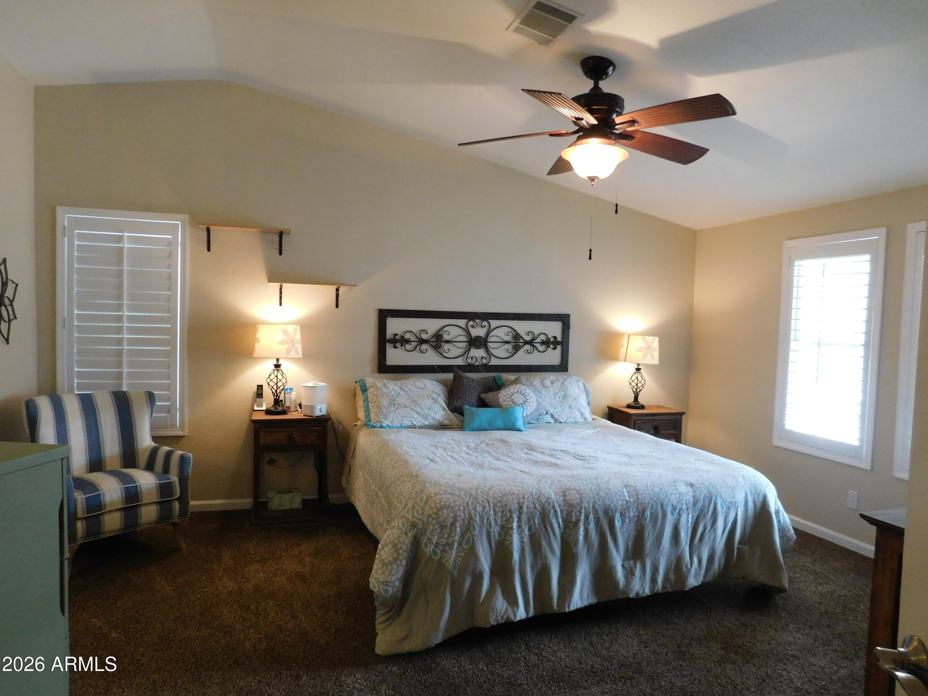 3301 South Goldfield Road, Unit 1054 Apache Junction, AZ 85119 - Photo 26 of 41 a bedroom with a bed and a chandelier