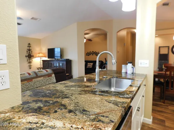 a kitchen with granite countertop a sink and a stove top oven