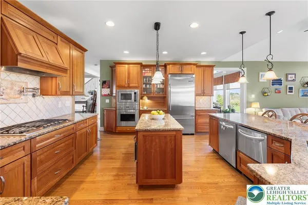 a large kitchen with stainless steel appliances granite countertop a stove and large cabinets