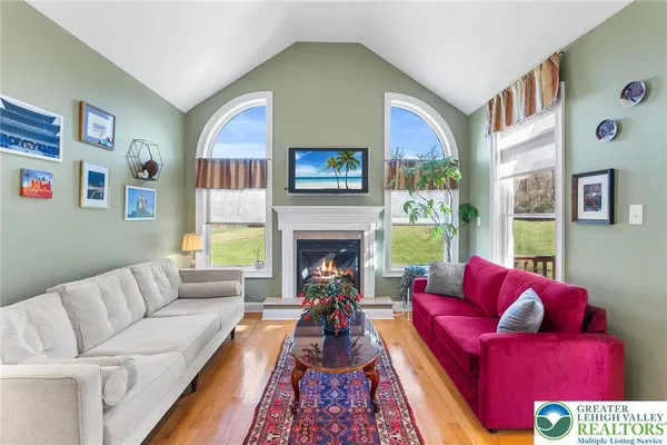 a living room with furniture fireplace and a large window