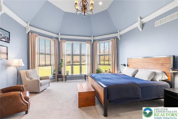 a bedroom with a bed couch and a chandelier