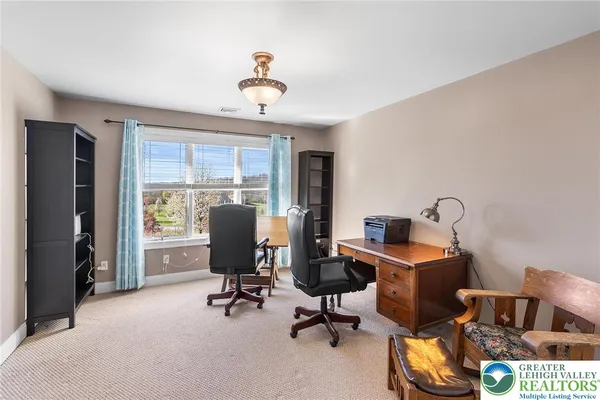 a view of a workspace with furniture and a window