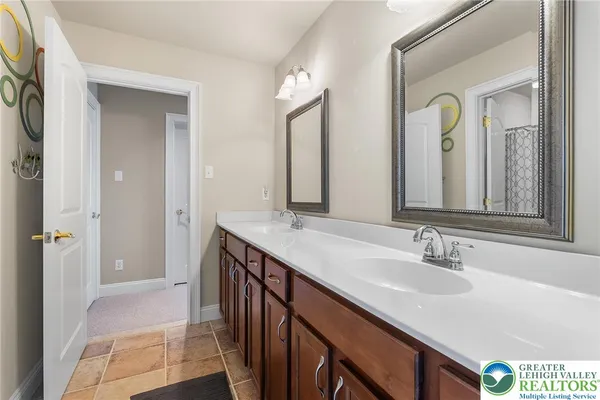 a en suite bathroom with a granite countertop sink and a mirror