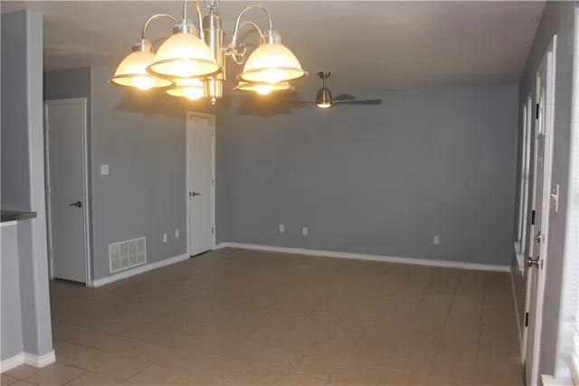 an empty room with closet and windows