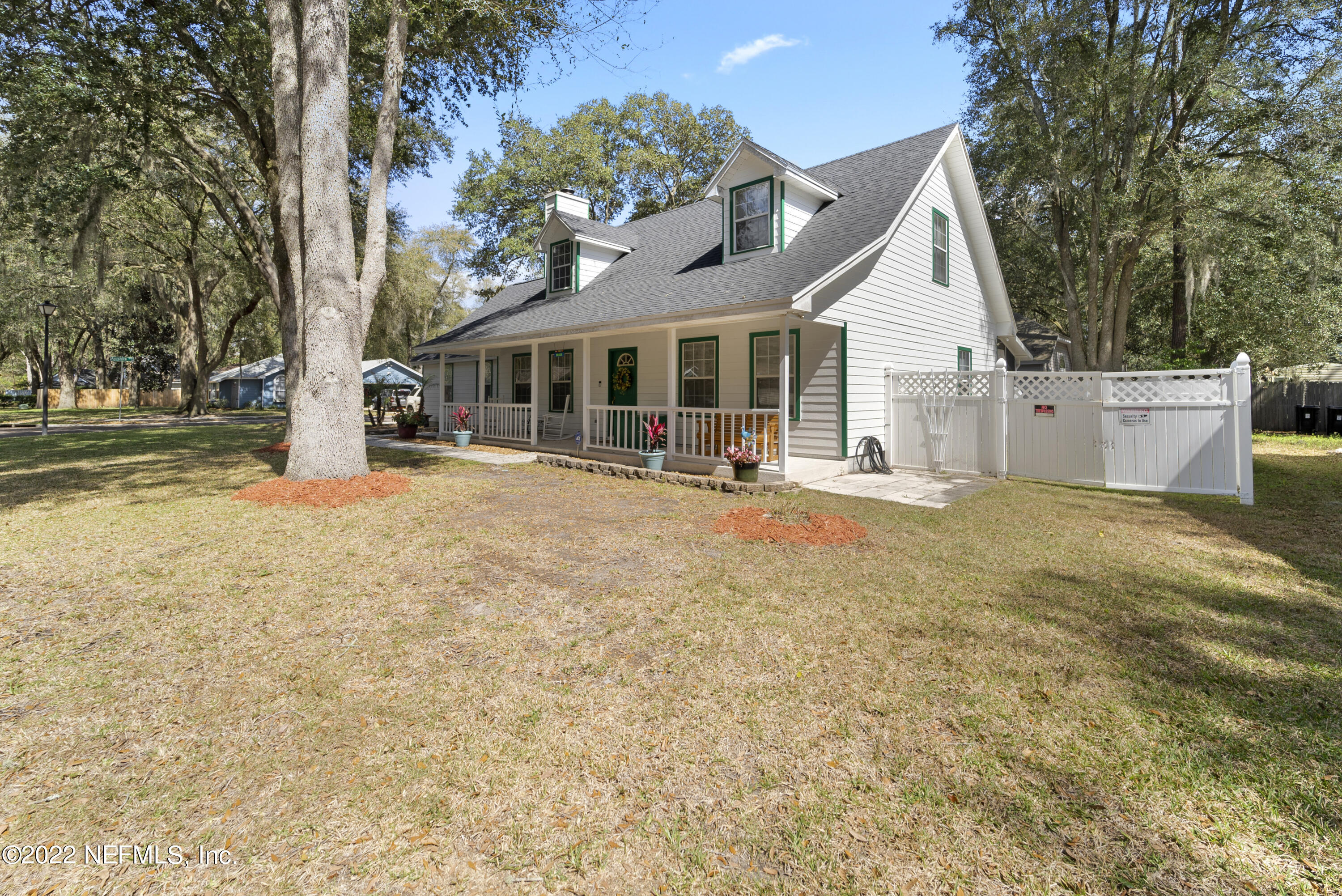 12855 Moose Road Jacksonville, FL 32226 - Photo 2 of 29 a view of a white house with a large tree and plants