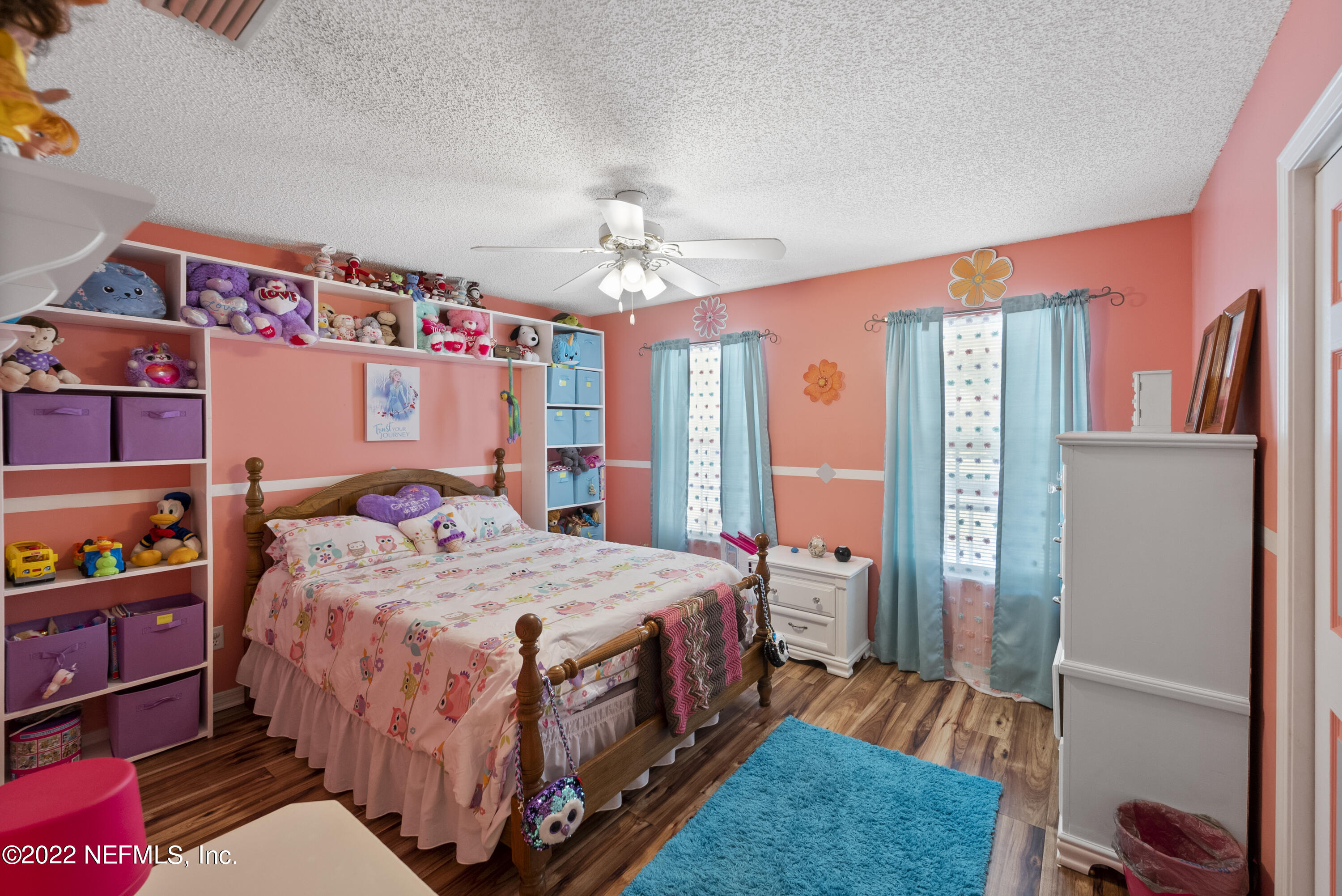12855 Moose Road Jacksonville, FL 32226 - Photo 21 of 29 a bedroom with a bed a dresser and wooden floor