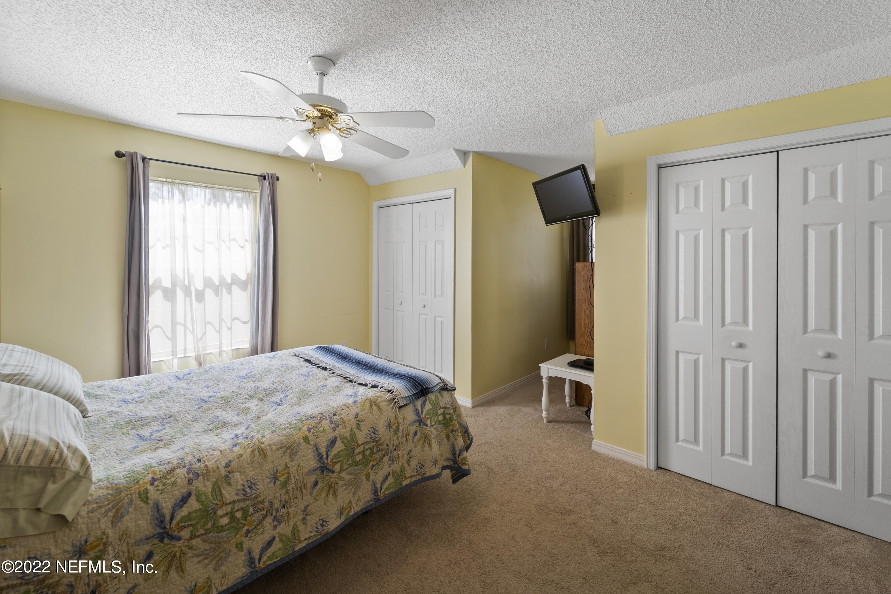 12855 Moose Road Jacksonville, FL 32226 - Photo 25 of 29 a bedroom with a large bed and a chandelier