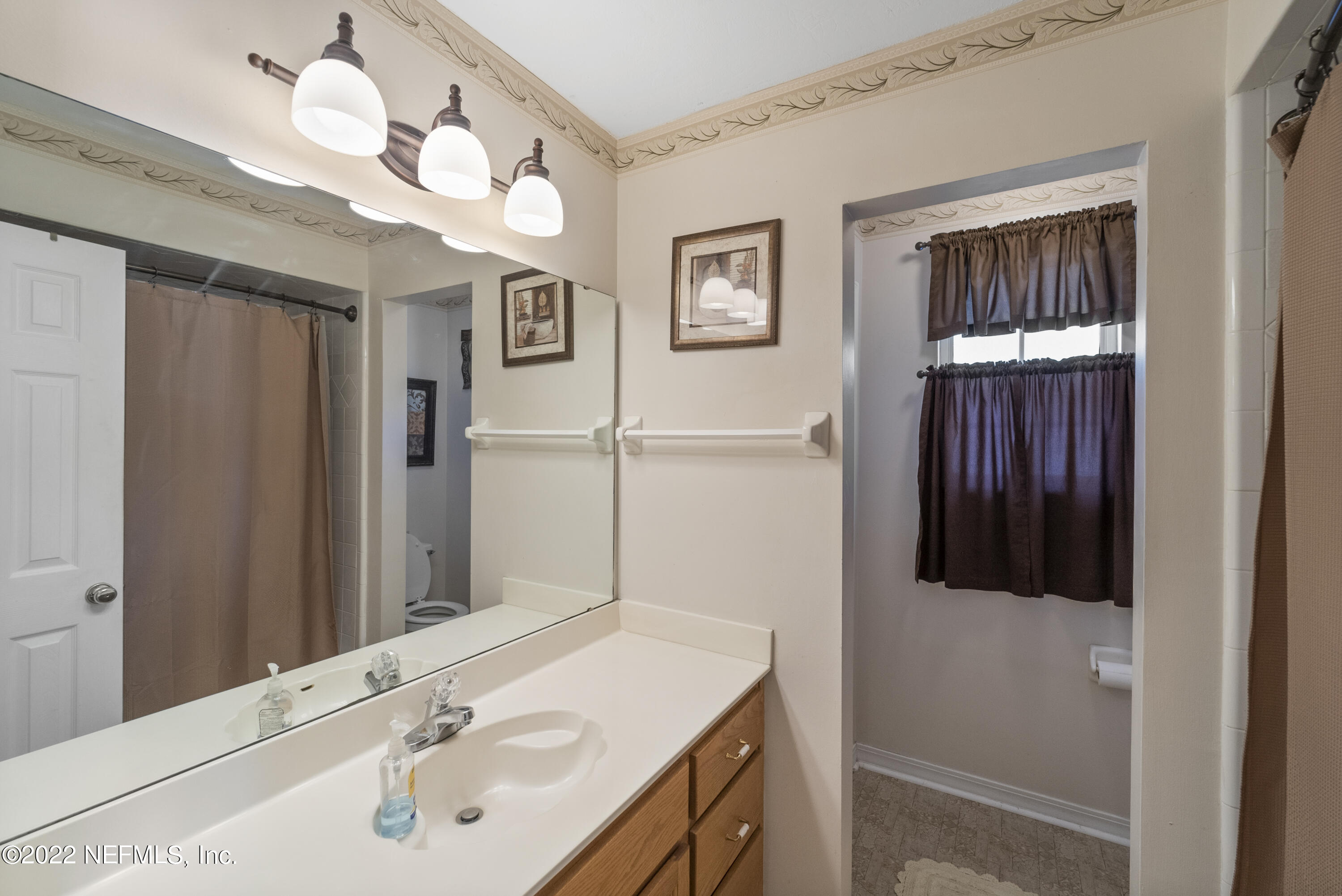 12855 Moose Road Jacksonville, FL 32226 - Photo 28 of 29 a bathroom with a sink vanity and a mirror