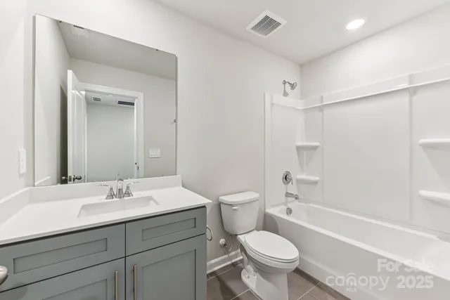 a bathroom with a sink toilet vanity and shower