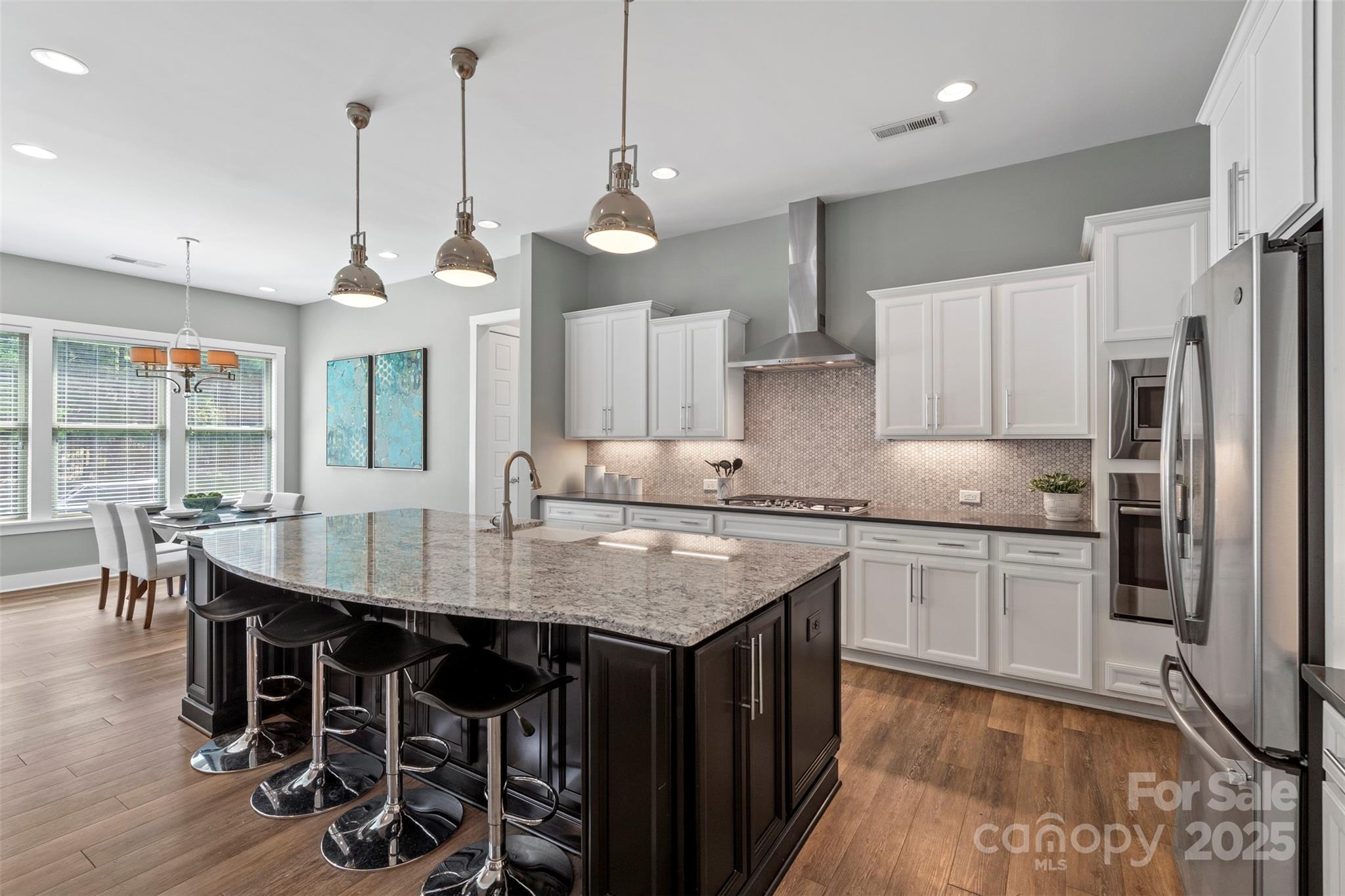 2052 Masons Bend Drive Fort Mill, SC 29708 - Photo 12 of 41 a kitchen with stainless steel appliances granite countertop a kitchen island a stove a table and chairs in it