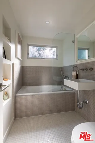 a bathroom with a bathtub a sink a toilet and a window