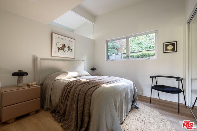 a bedroom with a bed and a lamp on dresser