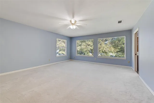 a view of an empty room with a ceiling fan
