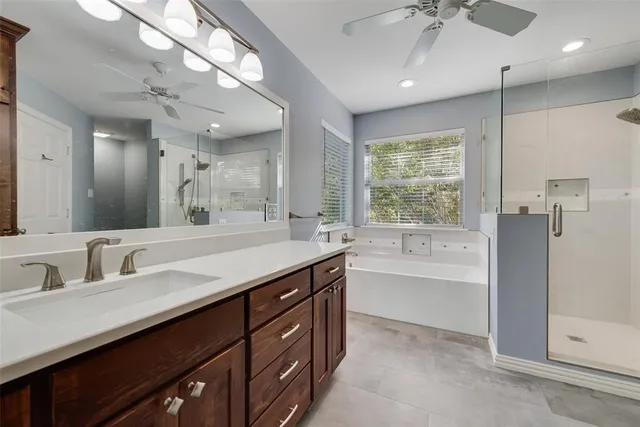 an empty room with chandelier fan and windows