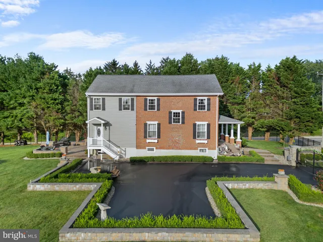 an aerial view of a house with swimming pool garden and trees