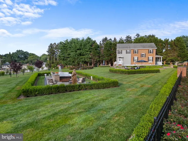 a view of a swimming pool with lawn chairs and plants