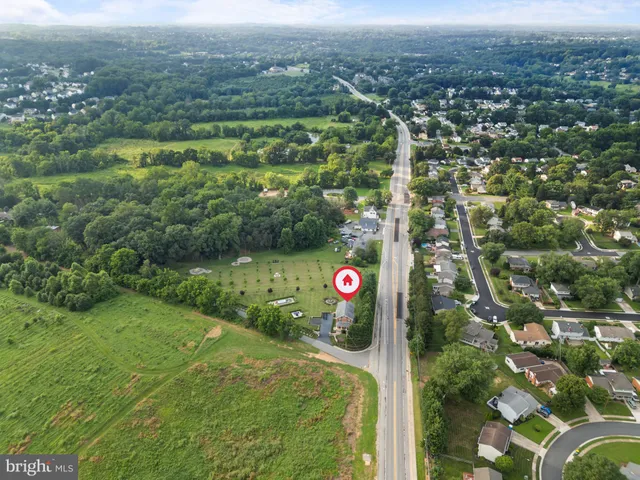 a front view of a house with a yard with potted plants