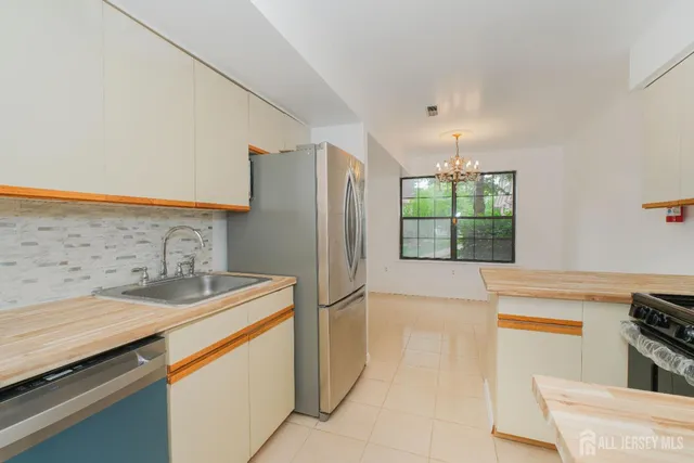 a kitchen with stainless steel appliances granite countertop a sink and a refrigerator