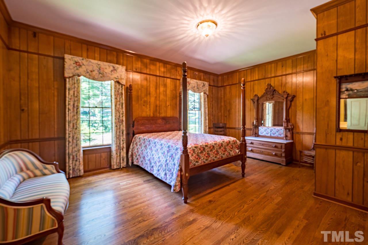 3210 Sussex Road Raleigh, NC 27612 - Photo 19 of 29 a bedroom with a bed and wooden floor