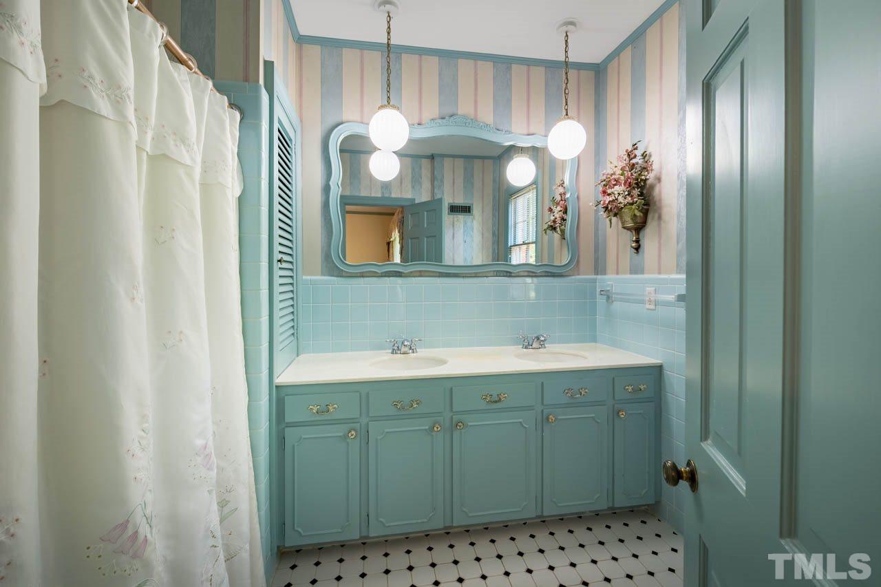 3210 Sussex Road Raleigh, NC 27612 - Photo 23 of 29 a bathroom with a sink a mirror and a shower