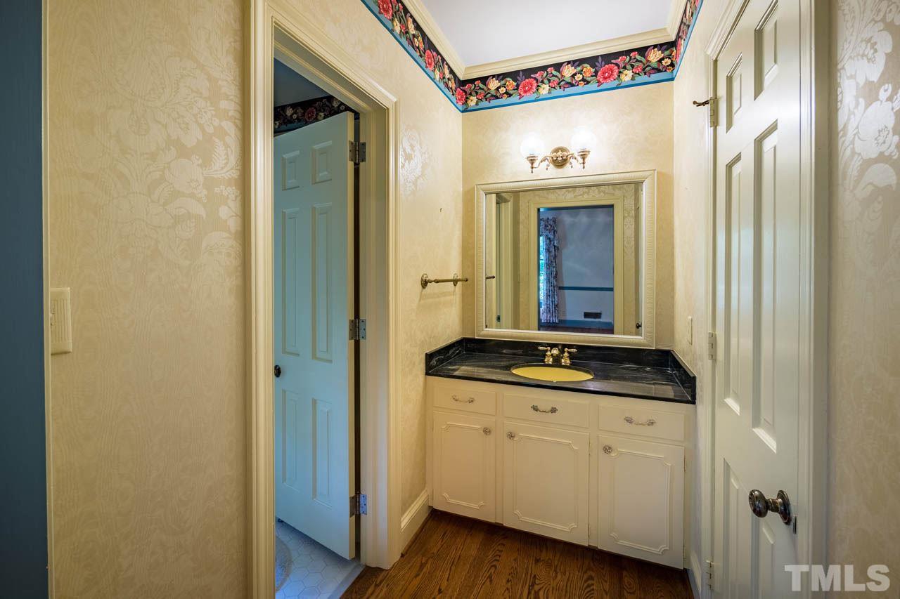 3210 Sussex Road Raleigh, NC 27612 - Photo 25 of 29 a bathroom with a granite countertop sink and a mirror