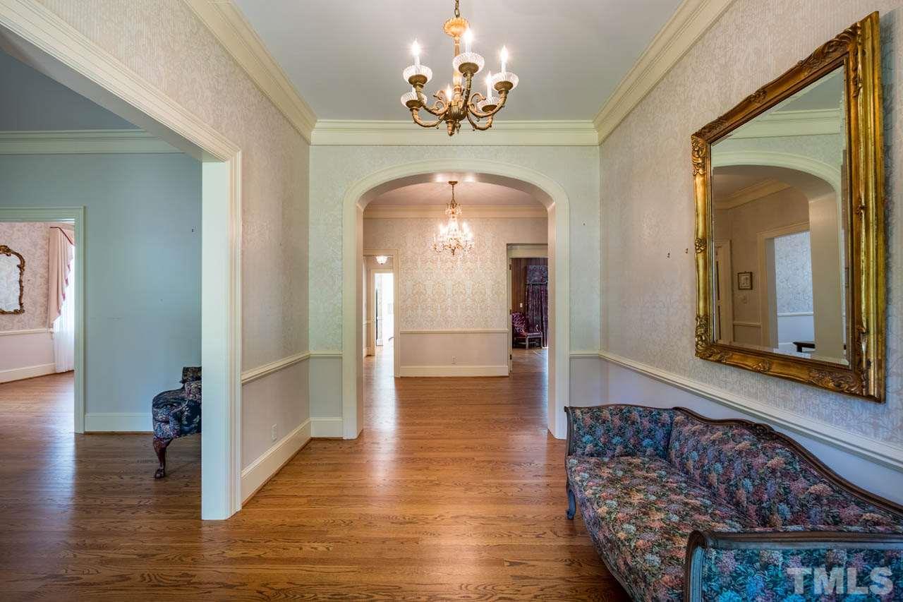3210 Sussex Road Raleigh, NC 27612 - Photo 5 of 29 a view of a hallway with wooden floor windows and a chandelier