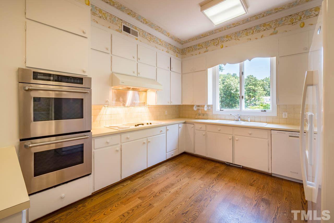3210 Sussex Road Raleigh, NC 27612 - Photo 10 of 29 a kitchen with granite countertop white cabinets and white appliances