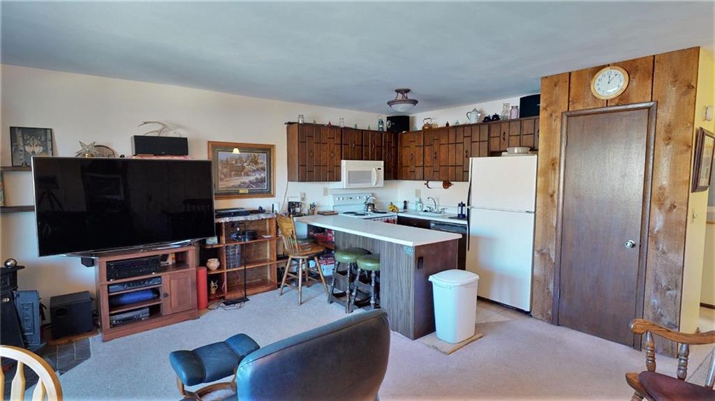 170 Evergreen Road, Unit 305 Dillon, CO 80435 - Photo 10 of 22 a kitchen with a refrigerator a stove and a dining table with wooden floor