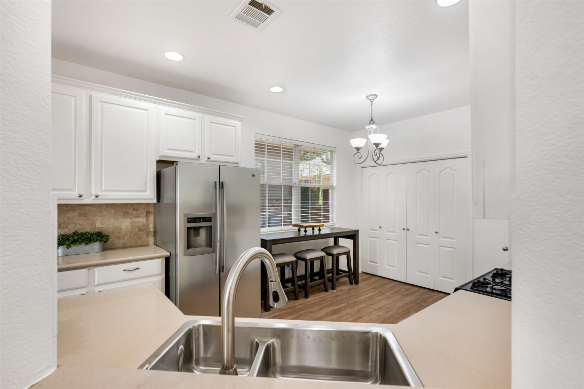 11000 Anderson Mill Road, Unit 63 Austin, TX 78750 - Photo 16 of 40 a kitchen with granite countertop a refrigerator a sink a stove and chairs
