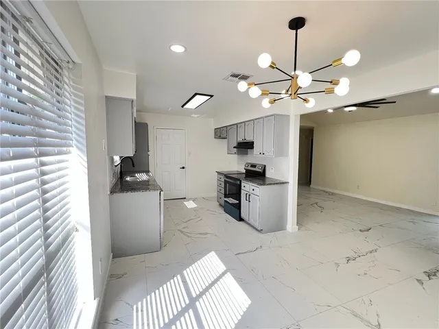 a kitchen with granite countertop white cabinets and sink