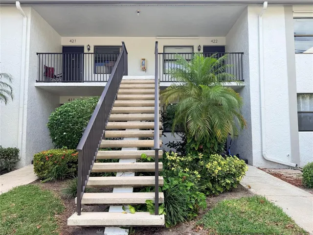 a view of a house with a yard and potted plants