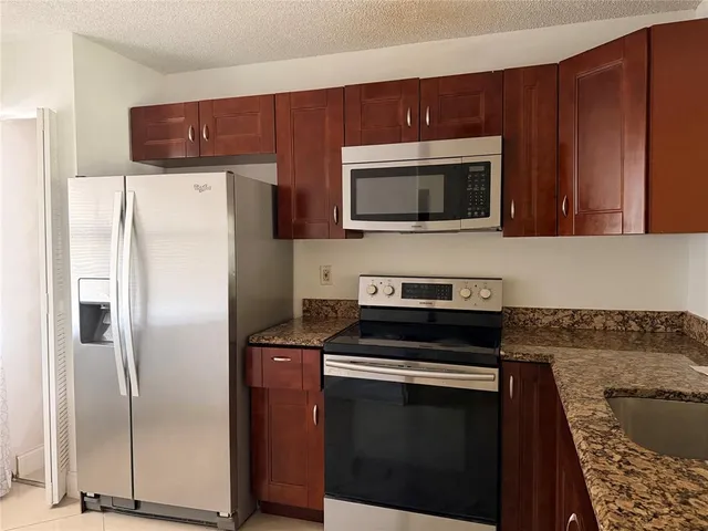 a kitchen with stainless steel appliances and wooden cabinets