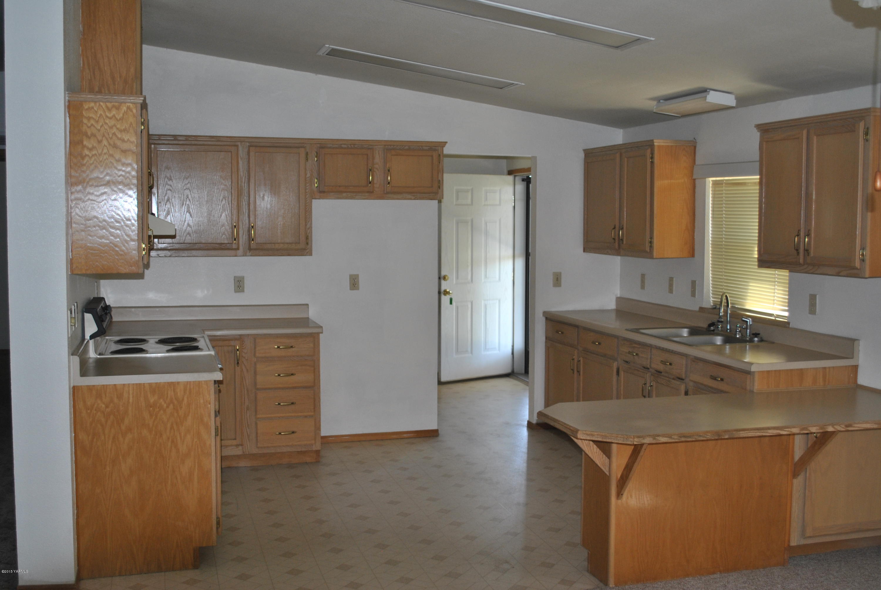 1211 Maple Grove Road Sunnyside, WA 98944 - Photo 3 of 5 a kitchen with kitchen island a sink stove and refrigerator