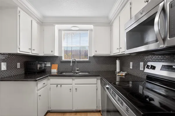 a kitchen with stainless steel appliances granite countertop a stove microwave and cabinets