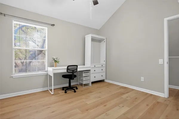 a view of a workspace with furniture and a window