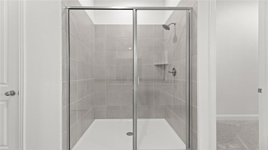 3809 Paradise Way Sherman, TX 75090 - Photo 11 of 16 a bathroom with a glass shower door