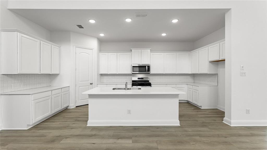 3809 Paradise Way Sherman, TX 75090 - Photo 4 of 16 a kitchen with kitchen island sink stove and cabinets