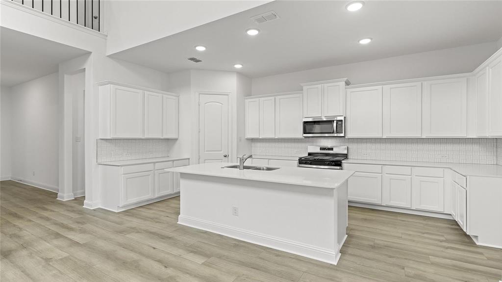 3809 Paradise Way Sherman, TX 75090 - Photo 5 of 16 a kitchen with white cabinets stainless steel appliances and sink