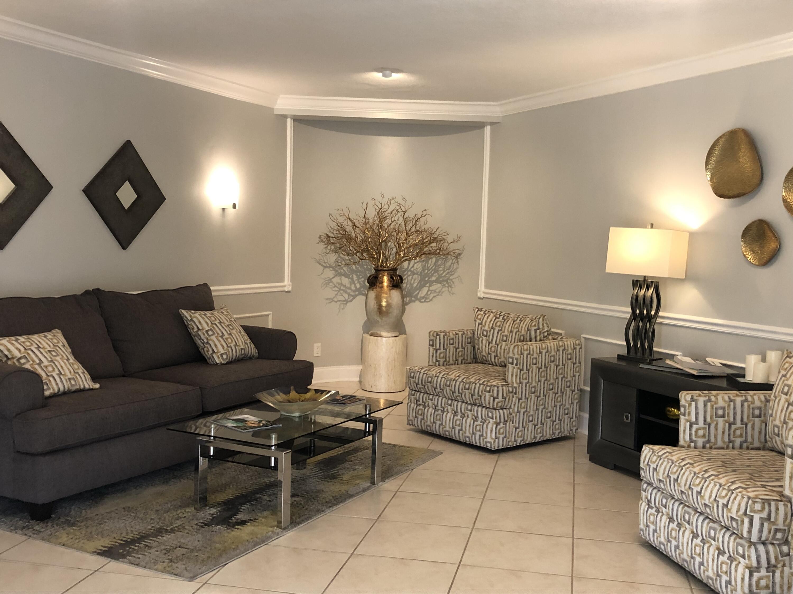 2871 North Ocean Boulevard, Unit M226 Boca Raton, FL 33431 - Photo 13 of 45 a living room with furniture and a lamp