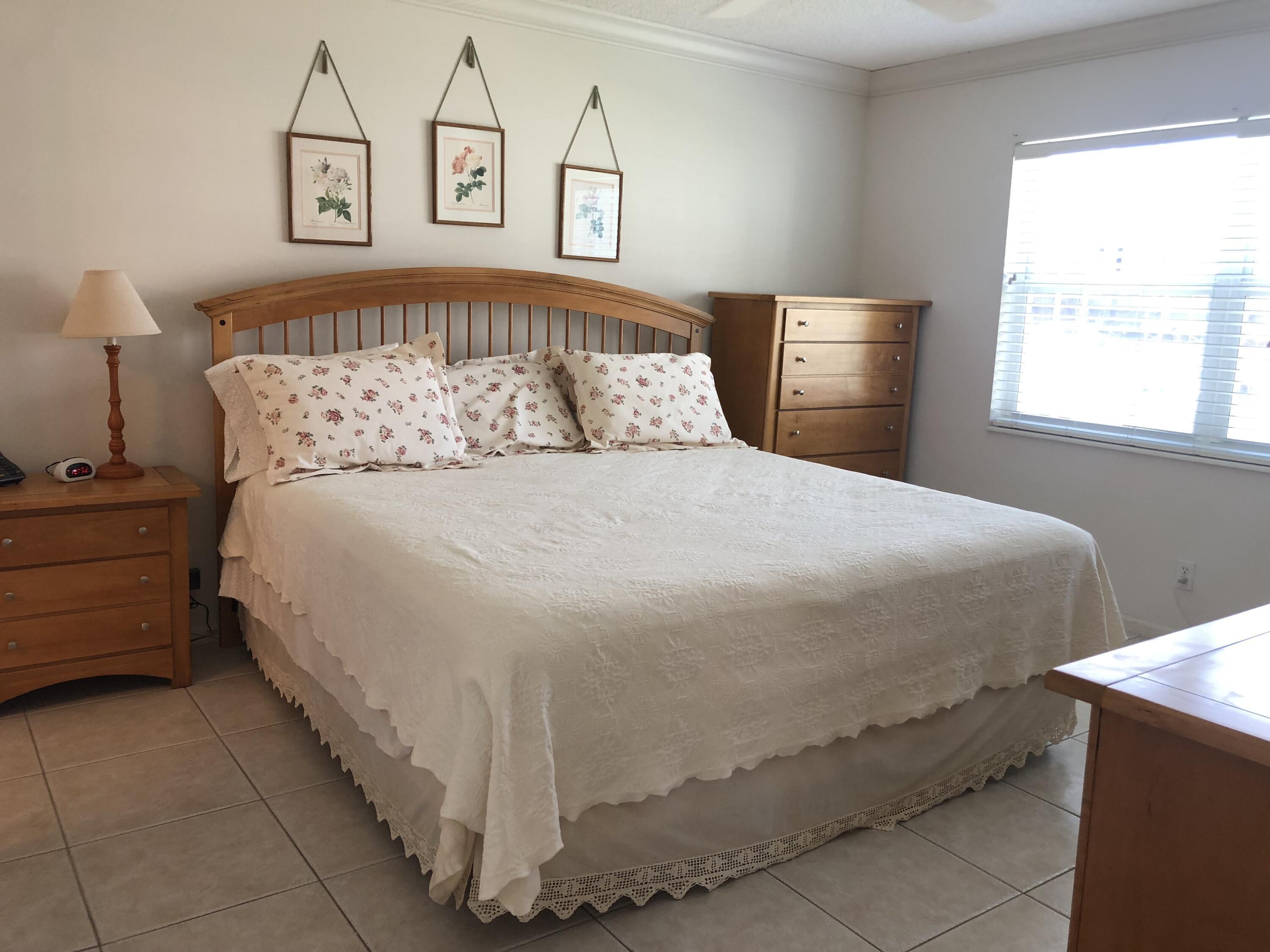 2871 North Ocean Boulevard, Unit M226 Boca Raton, FL 33431 - Photo 19 of 45 a large bed sitting in a bedroom next to a window