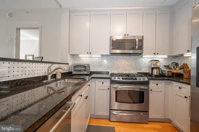 a kitchen with granite countertop a stove sink and cabinets