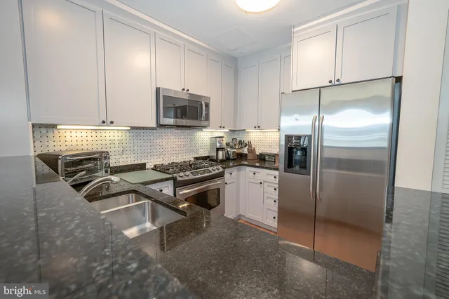 a kitchen with a refrigerator a microwave a sink and cabinets