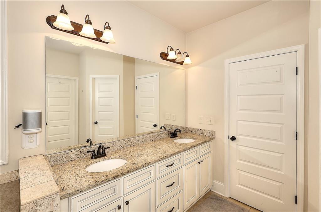 1079 Monticello Drive Monroe, GA 30655 - Photo 25 of 57 a bathroom with a granite countertop sink and a mirror