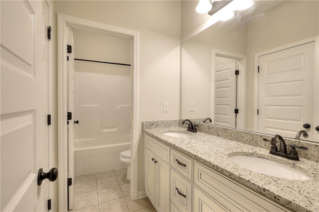 1079 Monticello Drive Monroe, GA 30655 - Photo 31 of 57 a bathroom with a granite countertop sink toilet and shower