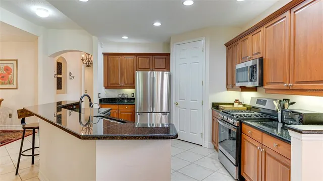 a kitchen with stainless steel appliances granite countertop a sink and wooden cabinets