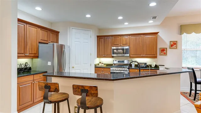 a kitchen with stainless steel appliances granite countertop a sink and a refrigerator