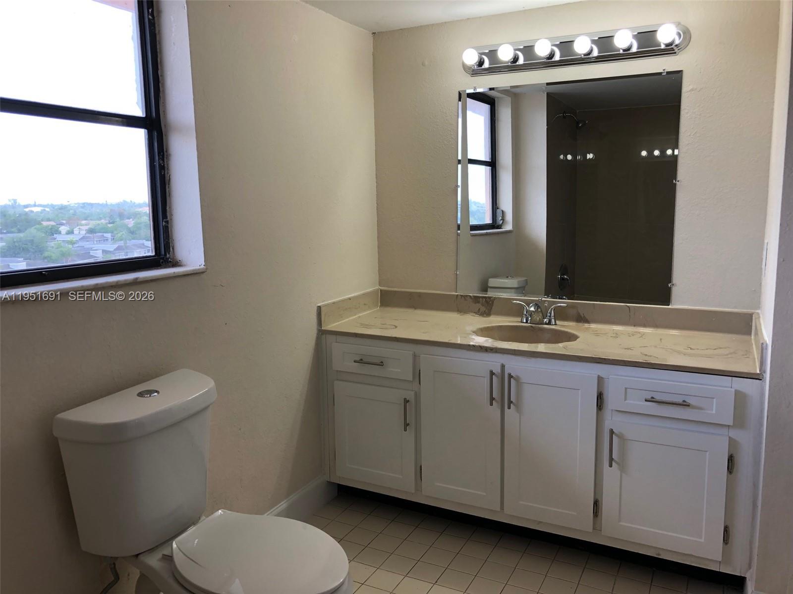 20840 San Simeon Way, Unit 702 Miami, FL 33179 - Photo 20 of 34 a bathroom with a toilet sink and mirror